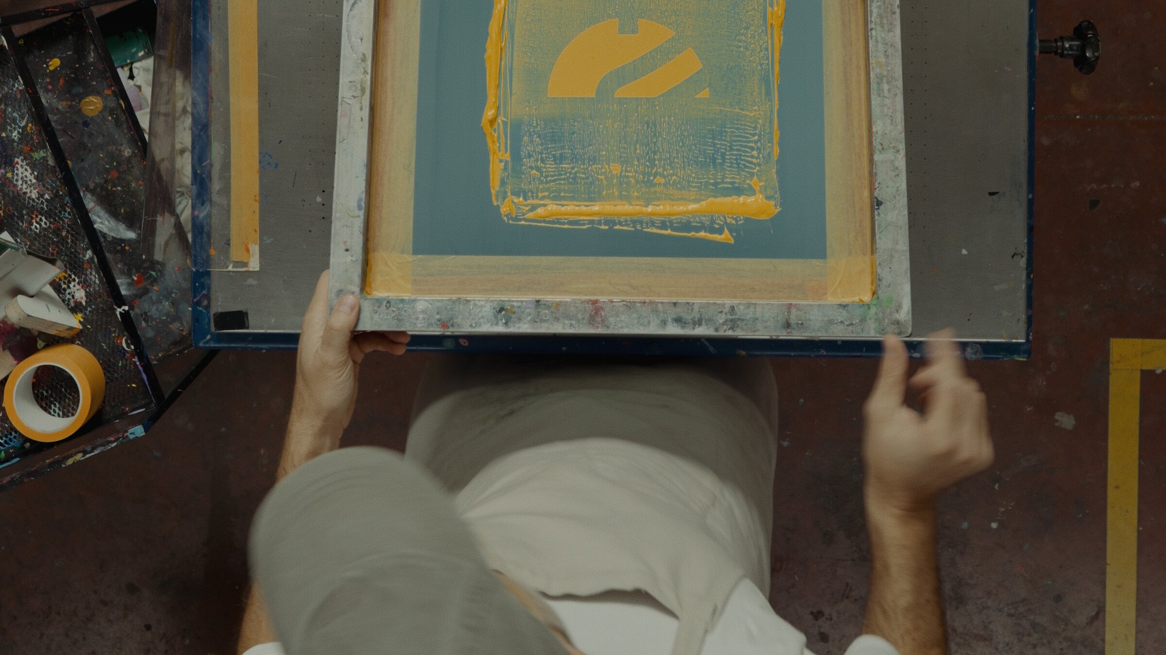 Close detail of ink and stencil on a screen-printing frame