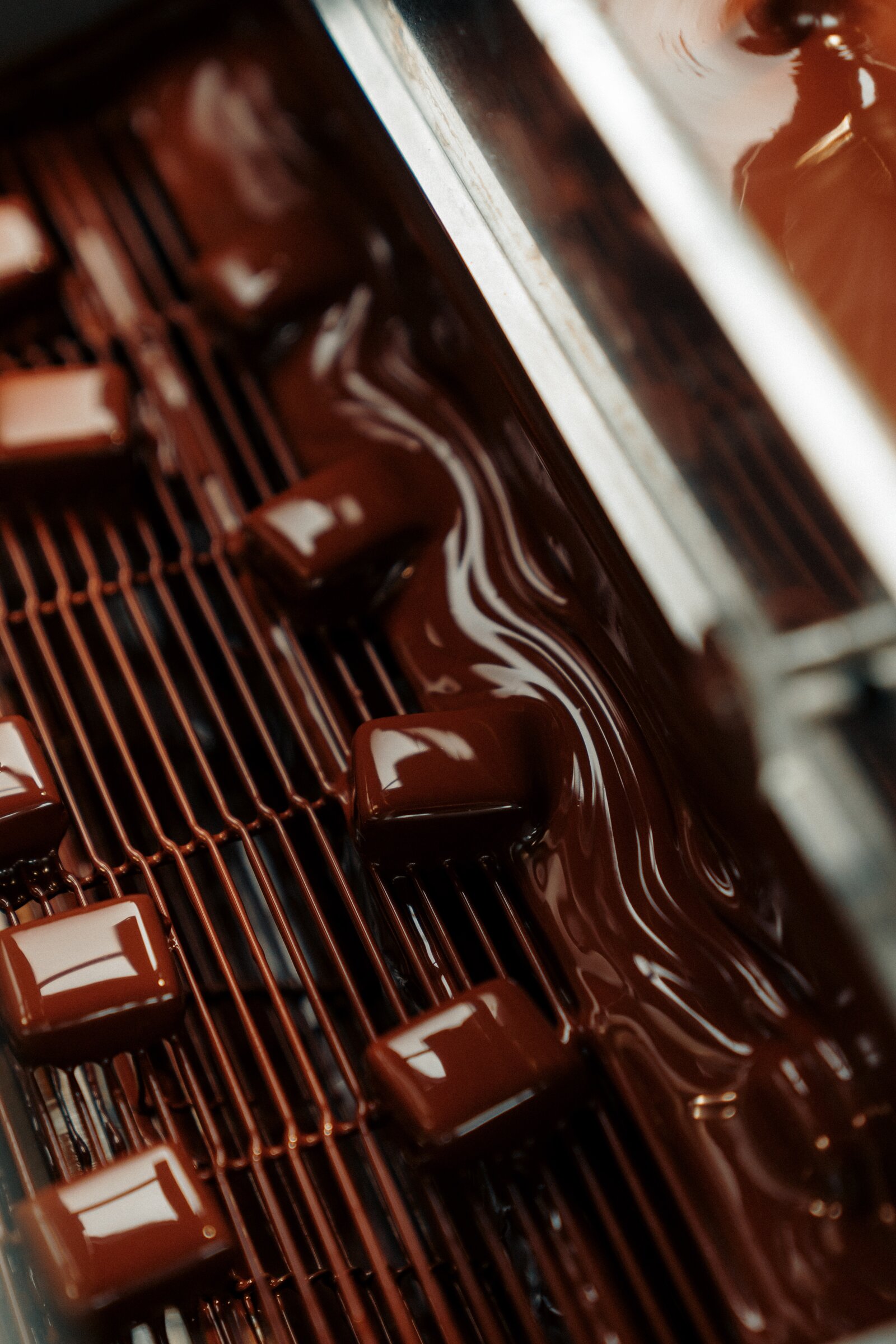 Chocolate pralines being enrobed at Benoît Nihant's atelier