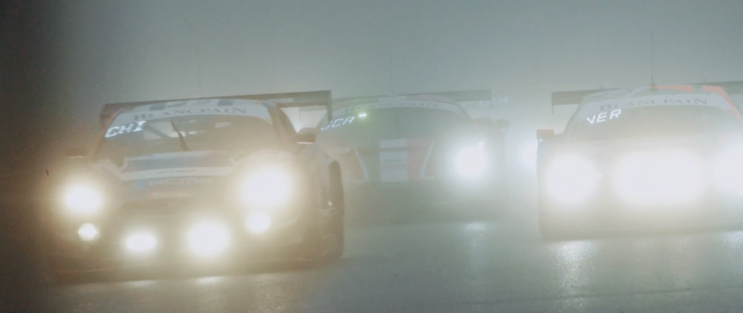 GT pack in dense fog, headlights glowing