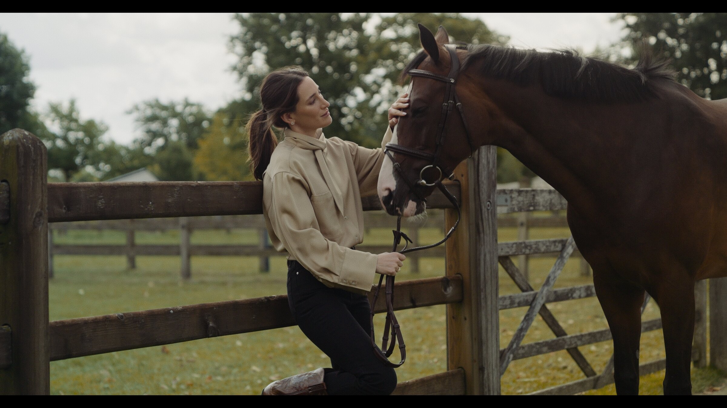 Rider and horse at a wooden paddock gate